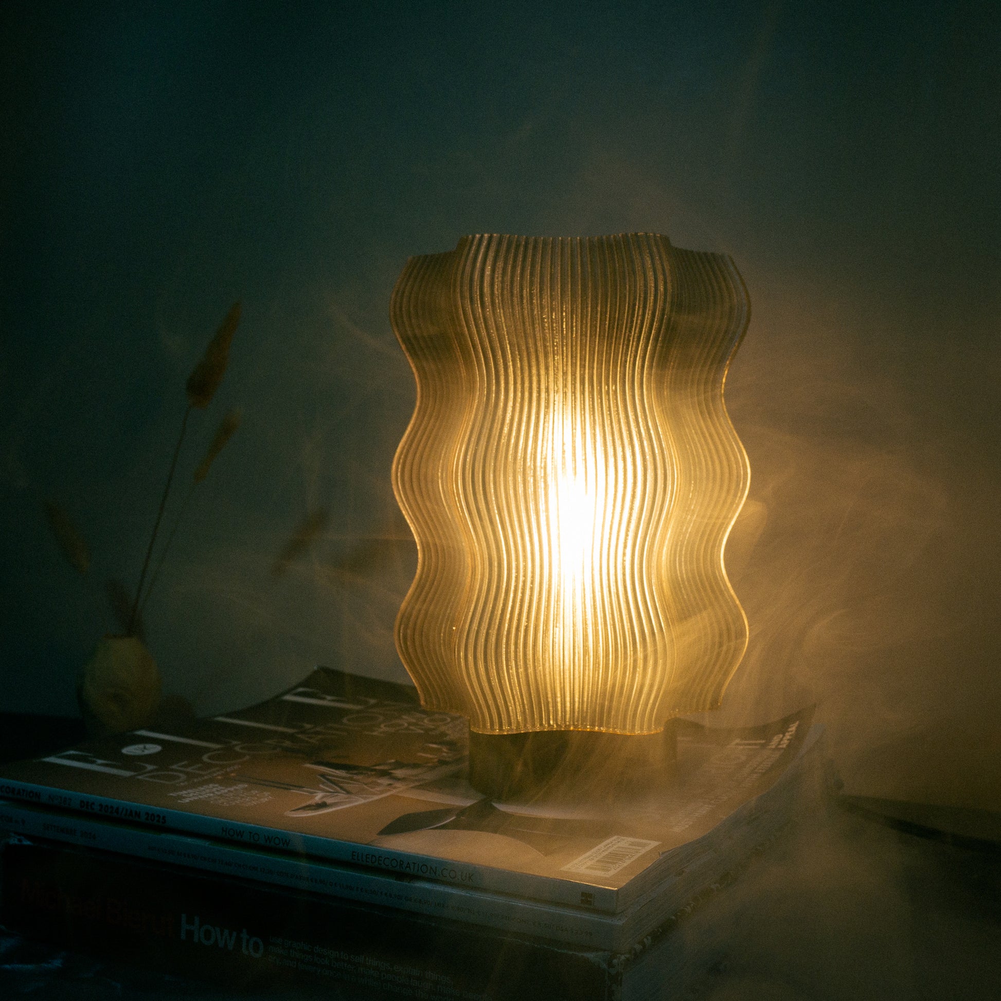 The Reef Table Lamp (Seconds) by OrijaDesign features flowing, coral-inspired curves and emits a warm, soft glow—perfect for adding modern charm and gentle illumination to any space.